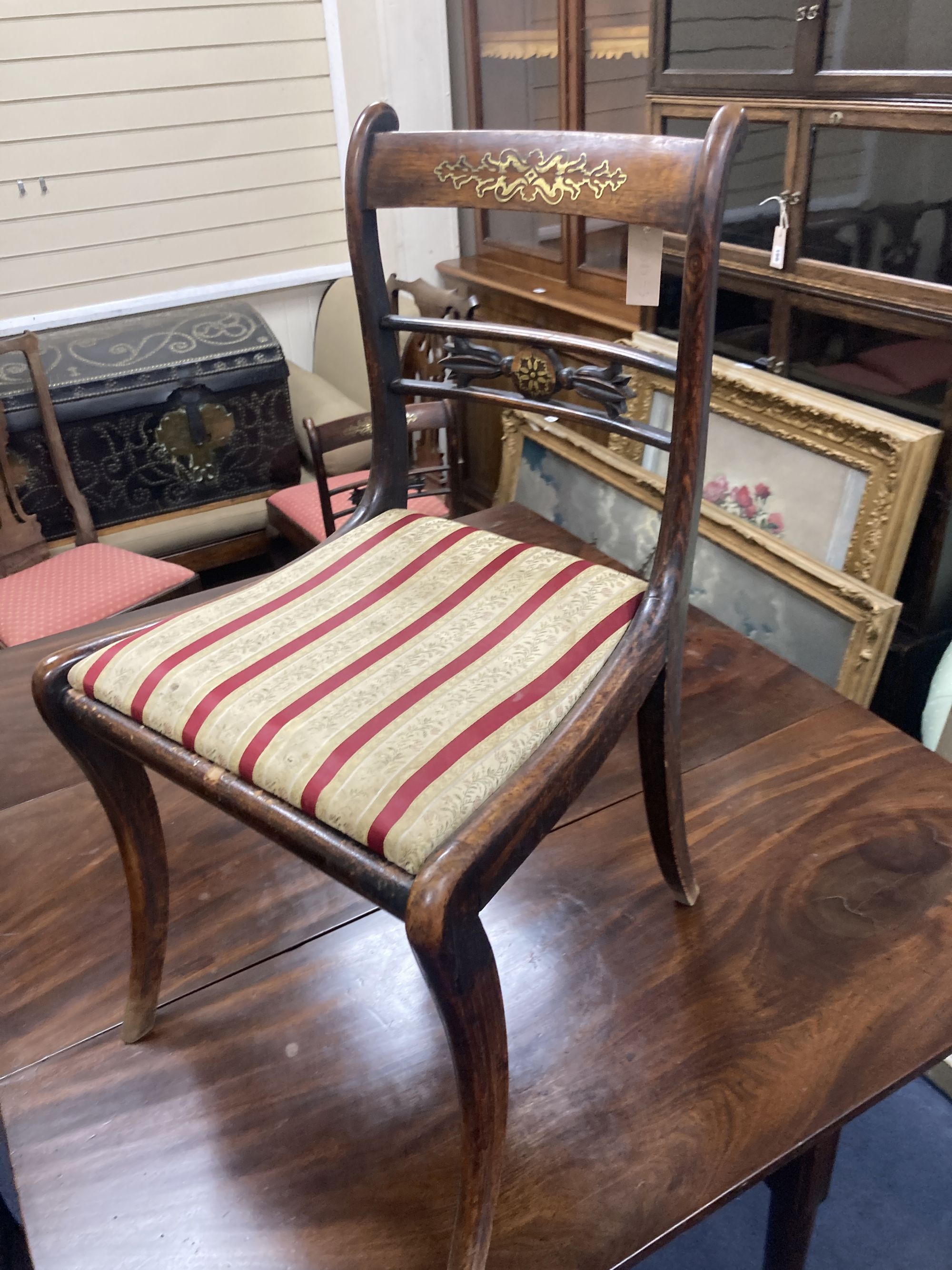 A set of five Regency brass inlaid simulated rosewood cane seated dining chairs